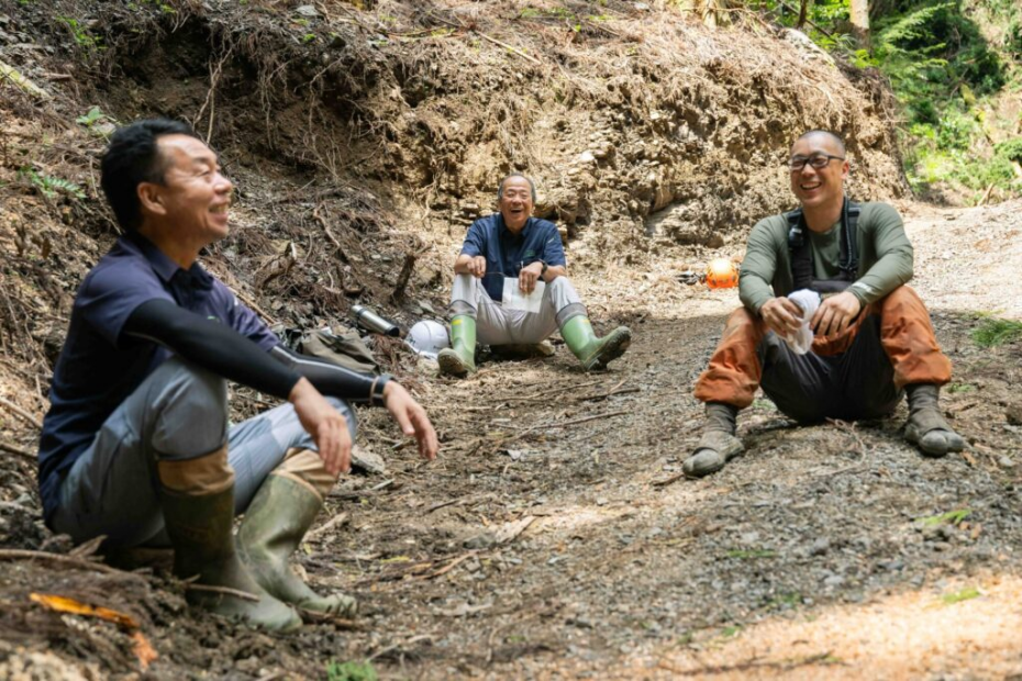 森林の中で談笑する藤田さんと仲間たち