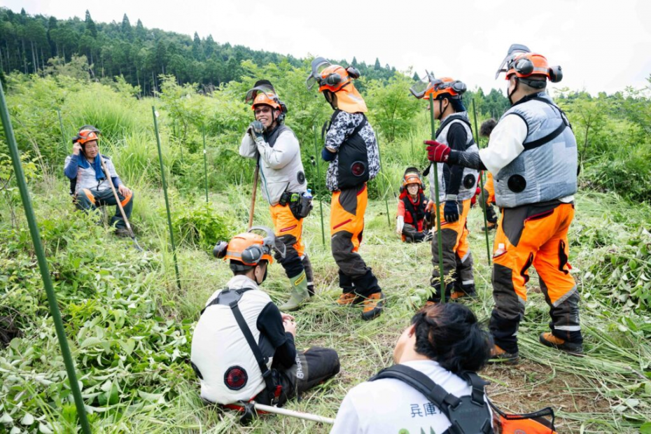 草刈りの実習の小休止に談笑する学生の様子